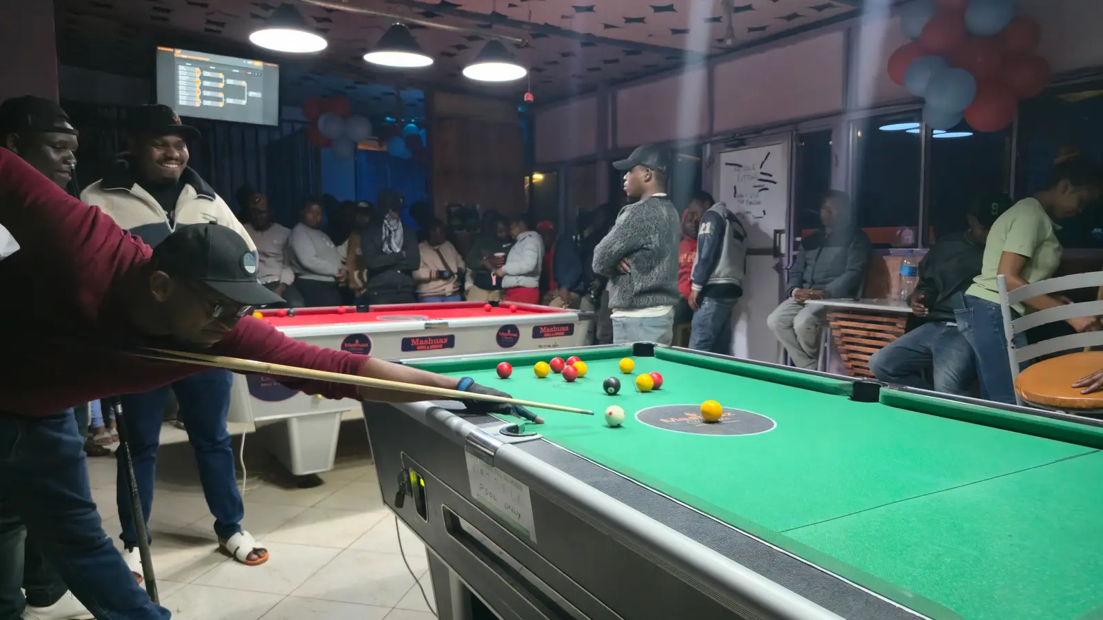 Players and a packed crowd at a Moran Pool Club tournament in Loitokitok