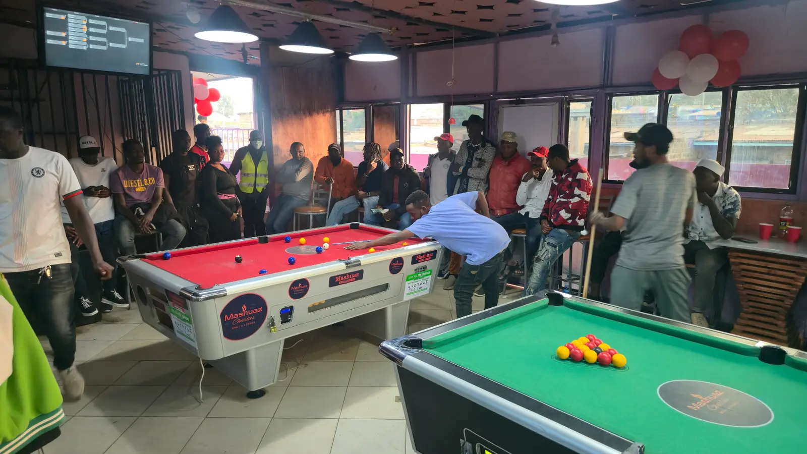 Players and spectators around the tables at Mashuaz Grill & Lounge
