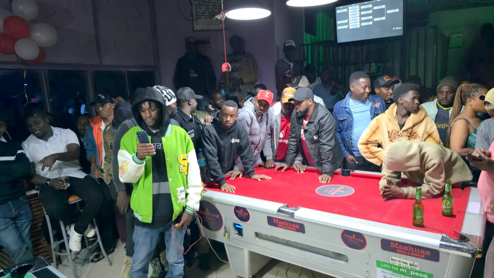 A packed crowd around the final table at the Penety Pool Tournament in Loitokitok